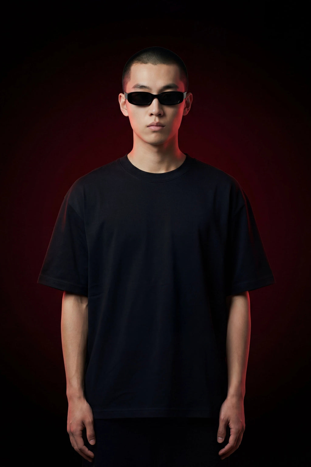 Person wearing a black t-shirt and sunglasses against a dark background