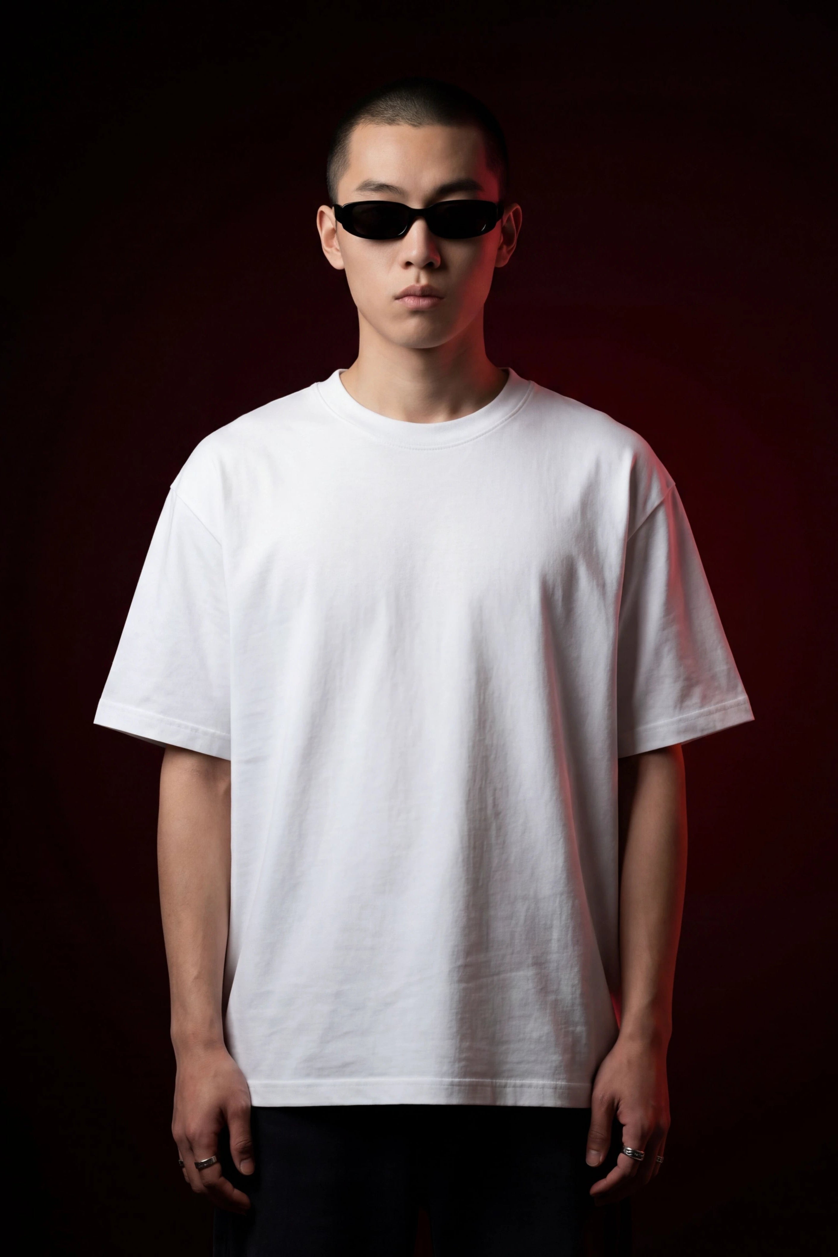 Person wearing a plain white t-shirt against a dark background